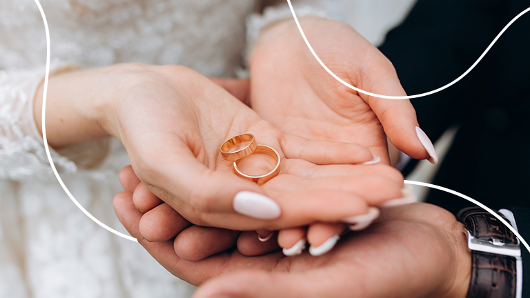 mãos de uma noiva segurando alianças de casamento nas mãos representando o dinheiro no casamento