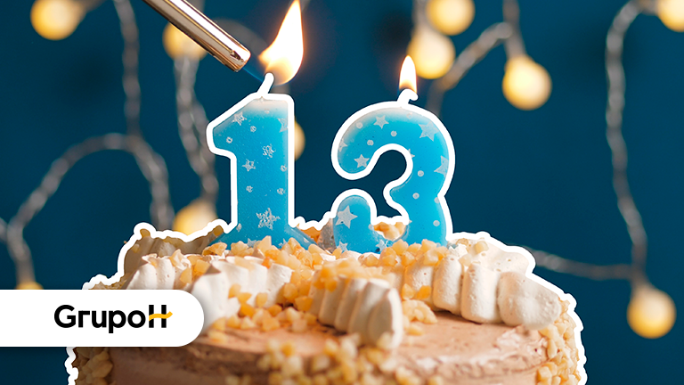 Imagem de um bolo com velas em azul com o número 13 nelas, representando a comemoração do 13º salário dos trabalhadores